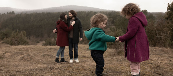 V Eine Familie mit Jacken aus Wollwalk in herbstlicher Landschaft