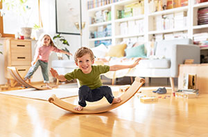 Kinder auf Balanceboard im Wohnzimmer