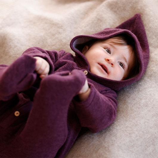 Baby in gemütlichem Schurwoll-Frottee-Overall
