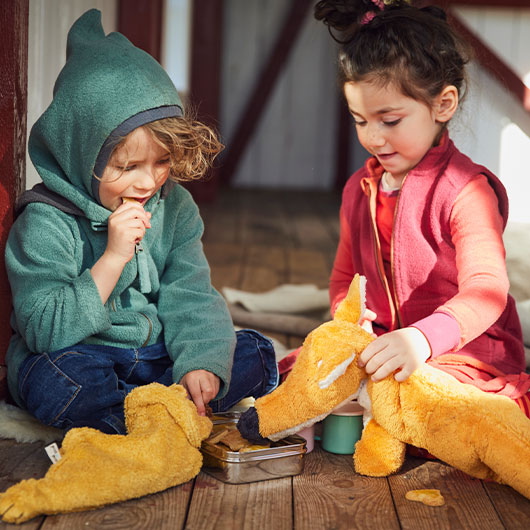 Kinder spielen mit Kuschltieren