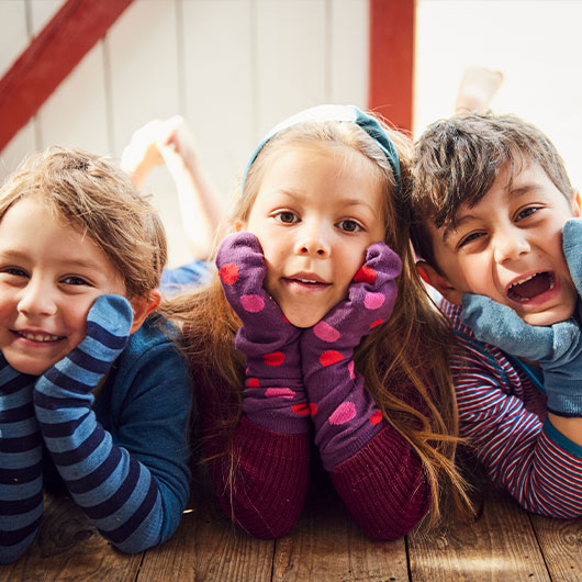 Kinder tragen nachhaltige und farbenfrohe Strümpfe auf ihren Händen